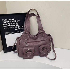 Detailed view of mauve tote bag with multiple pockets and vintage metal ring hardware