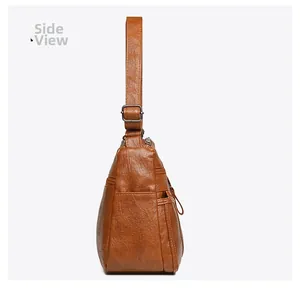Detailed side view of brown leather shoulder bag showing side zipper and metal buckle