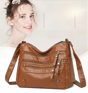 Detailed macro view of brown vintage PU leather bag with multiple zippers and rivets