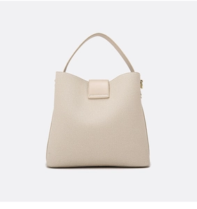 Detailed view of woven fabric texture and beige leather stitching on bucket handbag
