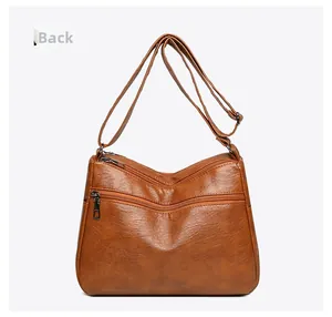 Detailed back view of a vintage caramel brown soft leather shoulder bag with zippers