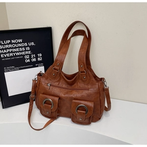 Detail of vintage brown PU leather tote with multi-pockets and metal ring decorations