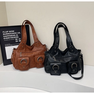 Detail of vintage tote bags in brown and black leather with large pockets and silver rings