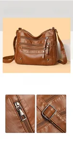Detail view of brown pebbled leather texture and silver metal zippers on crossbody bag