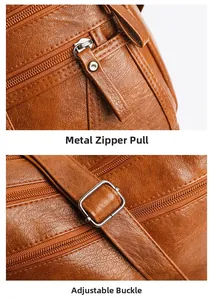 Detail of silver zipper pull and adjustable buckle on brown lychee leather shoulder bag