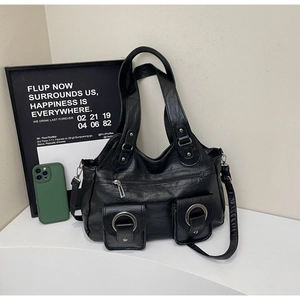 Detail view of retro black multi-pocket tote bag with silver metal rings and long strap