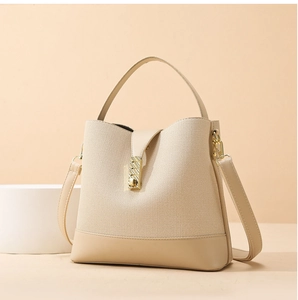 Detail of beige textured fabric and leather trim handbag with gold metal clasp lock