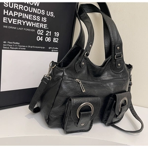 Detail view of black tote bag featuring two front pockets and litchi texture finish