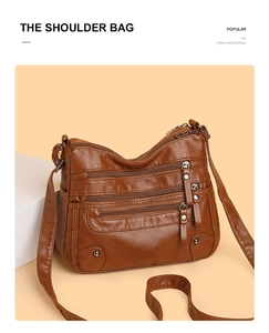 Detail view of the brown leather shoulder bag with multi-zipper pockets and metal studs
