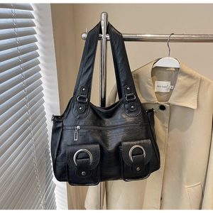 Detail of black vintage tote bag with silver metal rings and front flap pockets