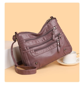 Detailed macro view of soft purple faux leather texture and multiple zipper pocket layers