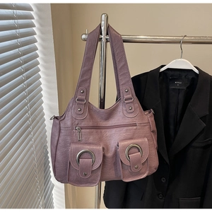 Detail of purple tote bag showing dual straps and decorative metal ring flap pockets