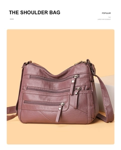 Detail of soft leather shoulder bag with multiple zippered pockets in dark rose brown