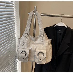 Detail of off-white pleated leather tote with metallic ring hardware and multi-pocket design