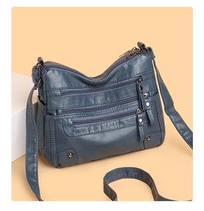 Detailed view of the blue multi-pocket soft PU leather crossbody bag with metal zippers