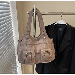 Detail of vintage tote bag featuring wrinkled PU leather and silver metal ring pockets