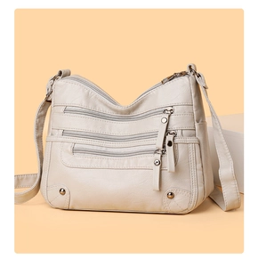 Close-up of ivory PU leather shoulder bag with pebbled texture and multi-pocket zippers