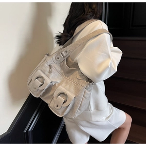 Silver grey tote bag with large metal ring pockets shown on model in stair setting