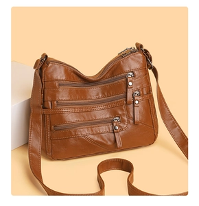 Detailed view of brown faux leather shoulder bag with multiple zippered utility pockets