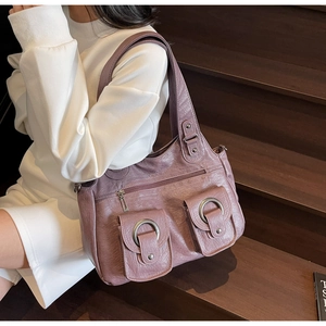 Macro shot of purple leather tote bag with vintage metal rings and double flap pockets