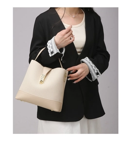Detail of beige composite leather handbag with gold metal clasp and textured fabric