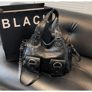 Detailed shot of black multi-pocket tote bag with metal rings on soft PU leather texture