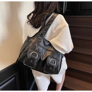 Detail of black PU leather tote bag with vintage texture and silver ring pocket buckles