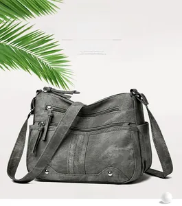 Détail du sac bandoulière gris en toile à fermetures éclair multiples et sangles larges