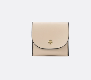 Close-up of small beige wallet featuring a gold circular buckle and black edge finish