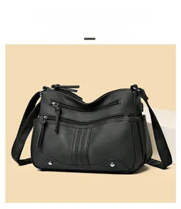 Détail du sac seau trapèze en similicuir noir avec fermetures éclair et clous métalliques