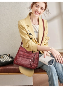 Detail view of burgundy multi-pocket crossbody bag with premium lychee texture leather