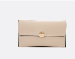 Detail of minimalist cream leather long wallet with round gold snap button closure
