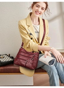 Detail showing high-capacity soft faux leather shoulder bag with multi-zippered pockets