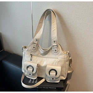 Detailed macro view of cream tote bag with multiple pockets and silver metal ring hardware
