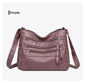 Detailed close-up of a soft purple PU leather shoulder bag featuring multi-zipper pockets