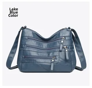 Macro view of lake blue soft leather shoulder bag with multiple front zipper pockets