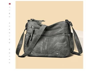 Détail du sac bandoulière multi-fermetures avec rivets et sangle en gris foncé