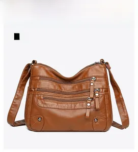 Detailed front view of a brown vintage faux leather crossbody bag with multiple zip pockets