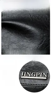 Macro shot of waterproof black pebble leather texture and metallic logo detail