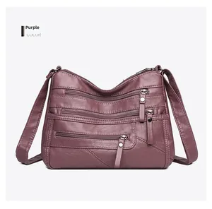 Macro detail of purple pebbled leather handbag with multi-zipper pocket design