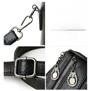 Detail of gunmetal hardware on black pebbled leather handbag with polished zipper pulls