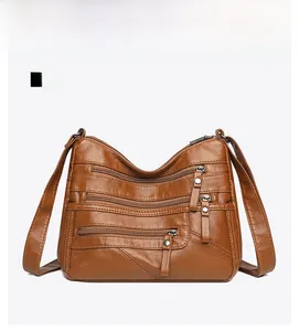 Close-up of brown PU leather shoulder bag featuring four functional front zipper pockets