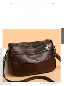 Detail view of large capacity dark brown leather bag with multi-layer zippers and strap