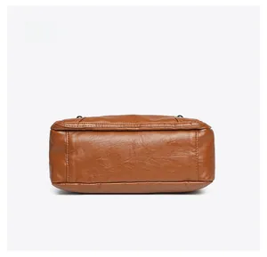 Detailed bottom view of brown soft leather shoulder bag with fine stitching and wide base