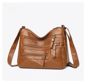 Macro side view of vintage brown soft leather shoulder bag with multiple zipper pockets