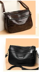Detail view of multi-compartment leather crossbody bags in brown and black finishes