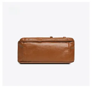 Detailed bottom view of brown pebble grain faux leather bag with reinforced stitching