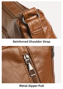 Detail of reinforced shoulder strap stitching and metal zipper on brown leather bag