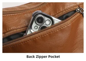 Close-up of the brown pebbled leather back zipper pocket with a smartphone inside