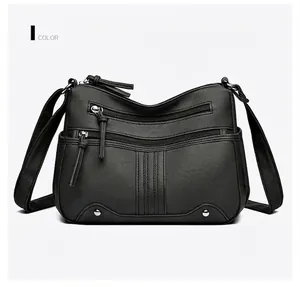 Détail du sac bandoulière noir en similicuir avec multi-fermetures et rivets argentés